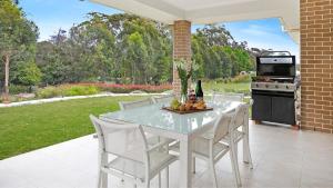 una mesa blanca y sillas en un patio en Forest Brae, en Bundanoon