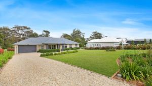 una casa con una entrada de grava y un patio en Forest Brae, en Bundanoon