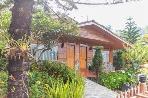 a wooden cabin with a fence in front of it at Zen Valley Dalat in Da Lat