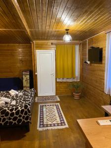 a room with a bed and a door with a rug at Wooden Cottages - Mtskheta in Mtskheta