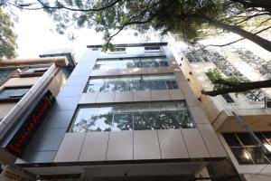 a tall white building with a lot of windows at Royal N Deluxe in Bengaluru