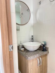 ein Badezimmer mit einem weißen Waschbecken und einem Spiegel in der Unterkunft Lujoso apartamento en el norte in Montería