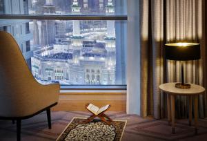 Habitación con ventana con libro y silla en Jumeirah Jabal Omar Makkah, en La Meca