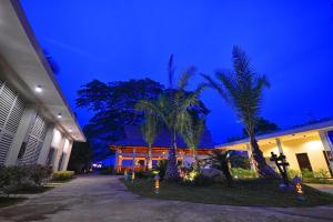 a building with palm trees in front of it at night at Munting Paraiso in Puerto Princesa City