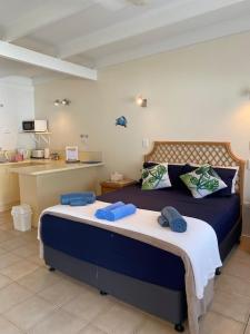 AFFORDABLE ISLAND ESCAPE! Queen Studio, Nelly Bay في خليج نيللي: غرفة نوم عليها سرير وفوط زرقاء