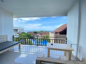 a balcony with a bench and a view of the ocean at Solaluna Beach Homestay in Amed