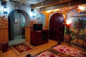 a room with a room with a door and a tv at Fort Mughaibar Resort in Hatta