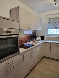 a kitchen with white cabinets and a stove top oven at Exclusivwohnung Hohenmölsen in Hohenmölsen