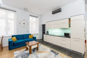 a living room with a blue couch and a kitchen at BlueApart with Terrace in Krakow