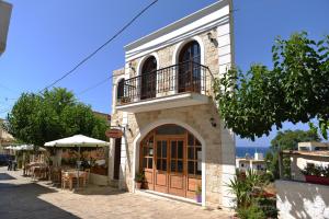 a building with a balcony on the side of a street at Castello Domus in Panormos Rethymno
