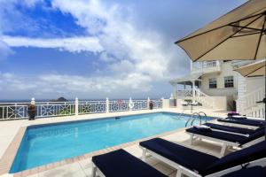 a swimming pool on a balcony with the ocean in the background at Brise De Mer - Villa with captivating views of the Caribbean Sea villa in Cap Estate