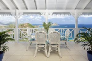 a white porch with a table and chairs and the ocean at Brise De Mer - Villa with captivating views of the Caribbean Sea villa in Cap Estate +27 photos