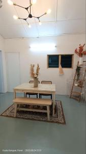 a table and bench in a room with a ceiling at Homestay Laman Dahlia in Kuala Kangsar