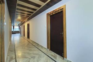 een hal met een zwarte deur in een witte muur bij Hotel Mehraz Residency in Haldwani