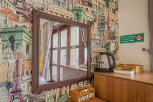 a mirror on a wall with a mural of cities at C'Lavie Hotel - Saigon Airport Hotel in Ho Chi Minh City