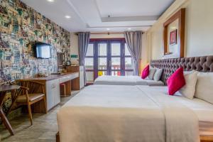 pokój hotelowy z 2 łóżkami i telewizorem w obiekcie C'Lavie Hotel - Saigon Airport Hotel w Ho Chi Minh