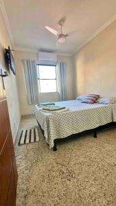 Schlafzimmer mit einem Bett und einem Fenster in der Unterkunft Casa 3 quartos com piscina e churrasqueira in Cabo Frio
