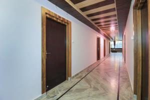 een hal met een zwarte deur en houten plafonds bij Hotel Mehraz Residency in Haldwani