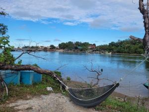 un bateau assis sur la rive d'une rivière dans l'établissement Homestay Cassia Marang, à Marang