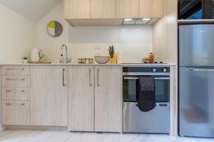 a kitchen with wooden cabinets and a blue refrigerator at Botanic Bliss Bungalow: 1 bed loft in Christchurch