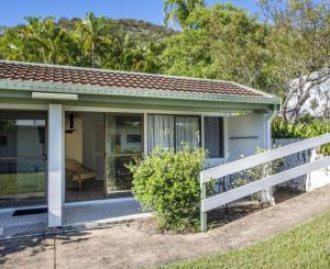 a small blue house with a white fence at AFFORDABLE ISLAND ESCAPE! Queen Studio, Nelly Bay in Nelly Bay