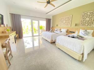 a large bedroom with two beds and a window at Solaluna Beach Homestay in Amed