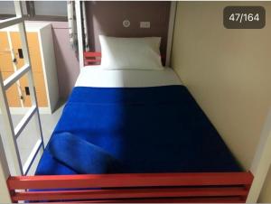 Cama pequeña en habitación pequeña con colchón azul en Captan Home, en Haad Chao Phao