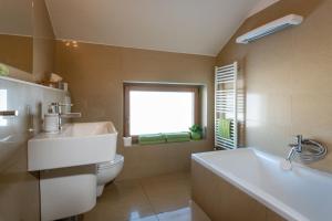 ein Badezimmer mit Badewanne und Toilette und einem Fenster in der Unterkunft Pension Lunatyk in Liptovský Mikuláš