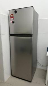 a stainless steel refrigerator in the corner of a kitchen at Home at Kota Puteri in Batu Arang