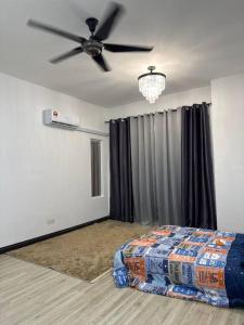 een slaapkamer met een bed en een plafondventilator bij Home at Kota Puteri in Batu Arang