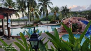 a pool at a resort with a rock slide at Villa Dalam Laut 538 in Pantai Cenang