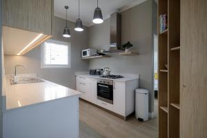 cocina con encimeras blancas y fogones en Villa Fontana 7, en Yzerfontein