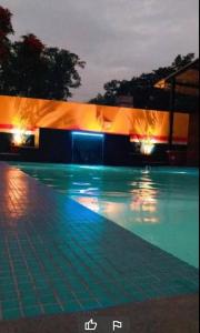uma piscina à noite com luzes acesas em Auspicious villa em Udaipur