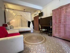 uma sala com um quarto com uma cama e um sofá em Auspicious villa em Udaipur