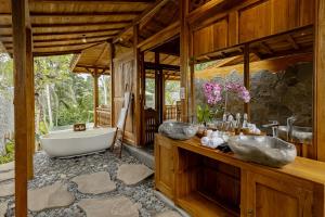 a bathroom with two sinks and a bath tub at Anandari Ubud Villa in Ubud