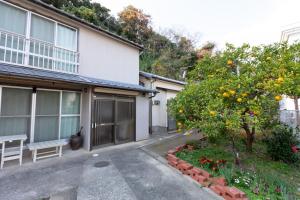 uma laranjeira em frente a uma casa em アルマス伊王島 em Nagasaki