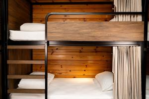 Haka House Aoraki Mt Cook في قرية جبل كوك: سرير بطابقين في كابينة ذات جدار خشبي