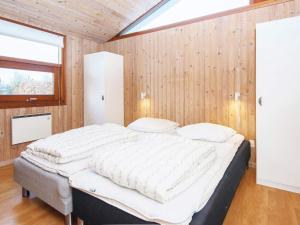 a large bed in a room with wooden walls at Secluded Retreat with Sauna - By Traum Ferienwohnungen in Sønderby