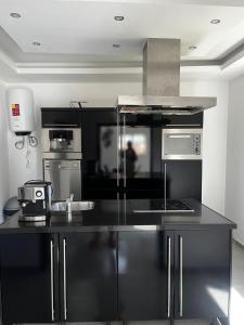a kitchen with black and stainless steel appliances at VILLA NAYELI Luxury and Simplicity in Órgãos