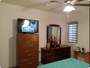 a bedroom with a tv on top of a dresser at Habitación con Jacuzzi Crismar in Aguascalientes
