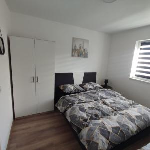 a bedroom with a bed and a white cabinet at Apartman Čolić - Kupres in Kupres