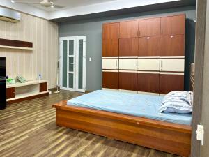 um quarto com uma cama grande e uma cabeceira em madeira em Homestay Linh em Ho Chi Minh
