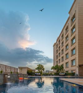 una piscina di fronte a un edificio di Holiday Inn Agra MG Road an IHG Hotel ad Agra