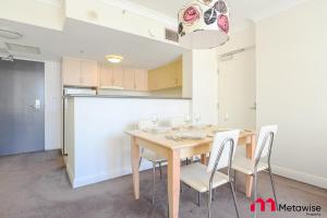 a dining room with a wooden table and chairs at MetaWise Chatswood 1Bed next to station in Sydney