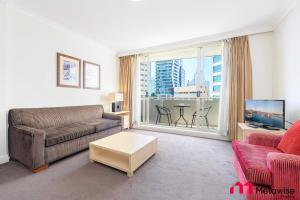 a living room with a couch and a large window at MetaWise Chatswood 1Bed next to station in Sydney