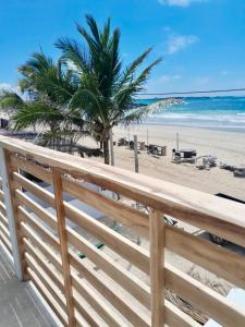 a view of the beach from a wooden fence at Yellow Heron House in Puerto Villamil