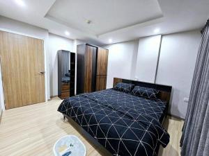 a bedroom with a bed with a black comforter at Family&Studio-Room in Phra Nakhon Si Ayutthaya