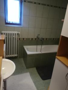 y baño con bañera y lavamanos. en Apartmán Nina, en Oravská Polhora