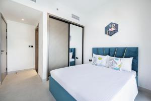a bedroom with a white bed with a blue headboard at Homesgetaway - Ultraluxury 1BR in Binghatti Creek - Al Jaddaf in Dubai