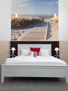 a bedroom with a bed and a painting of a pier at Amical Hotel in Wuppertal